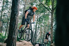 活跃的年轻试验骑自行车在美丽的森林