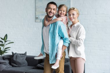 幸福的家庭微笑着在相机, 而花时间在一起在家 幸福的家庭微笑着在相机, 而花时间在一起在家