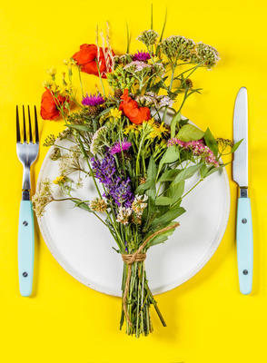 平躺在白色盤子上的野花花束。潔食, 古, 生物黑客, 草藥概念