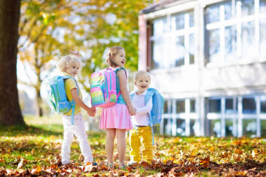 孩子们回到学校去。暑假后新学年开始.开学第一天带着背包和书本的男孩和女孩。开始上课。幼儿园和学龄前儿童的教育