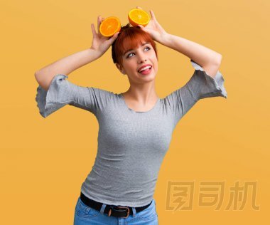 橙色背景的年轻红发女孩举行橙色