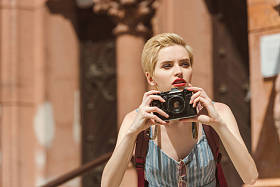 美丽的女孩拍照相机在城市照片