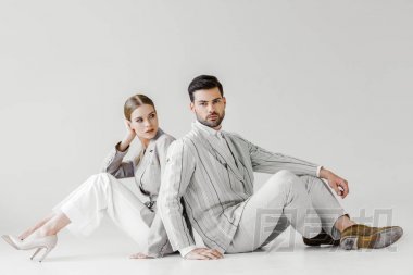 夫婦在老式的衣服坐在地板上, 靠在白色的漂亮的模型