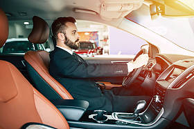 自信英俊男子在西装驾驶车 