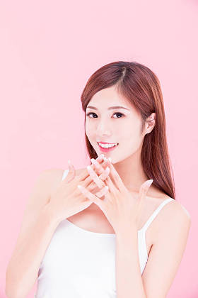 美容护肤女人微笑在粉红色的背景