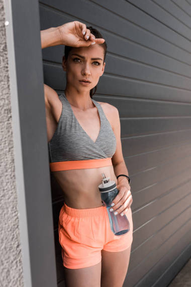 美麗的運動婦女拿著運動瓶水