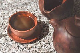 用粘土杯酿造的黑中国普洱茶。茶道陶瓷制品的组成