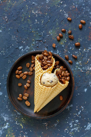 饼干锥与咖啡冰淇淋和咖啡豆在黑暗的垃圾背景。从顶部查看