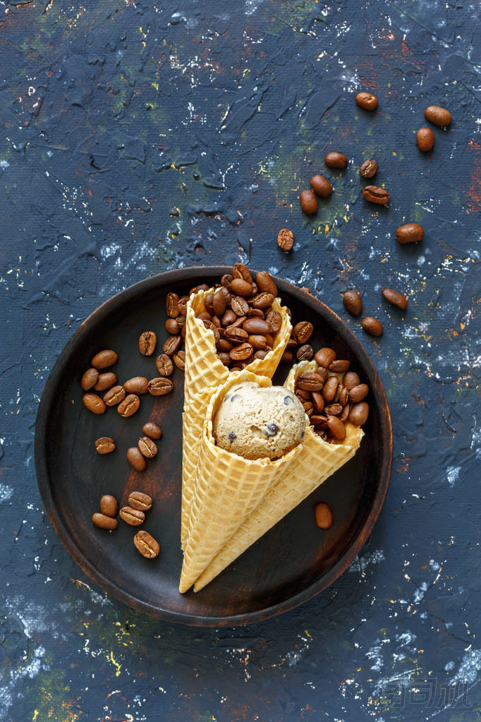 餅干錐與咖啡冰淇淋和咖啡豆在黑暗的垃圾背景。從頂部查看
