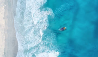 波浪和小船在海灘作為背景。美麗的自然背景在夏天時間從空氣