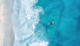 波浪和小船在海滩作为背景。美丽的自然背景在夏天时间从空气