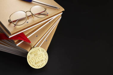 教師日賀卡與筆記本, 鋼筆, 眼鏡和金牌在黑色背景