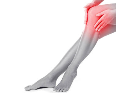 婦女在她的膝蓋痛苦在白色背景