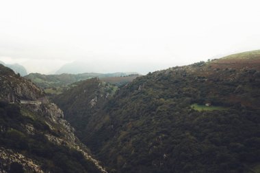 清晨的薄霧之家在山巔的自然景觀。綠色的山谷背景上有大霧的天空, 山頂。全景視野景觀丘陵景觀。旅行樣機(jī)概念