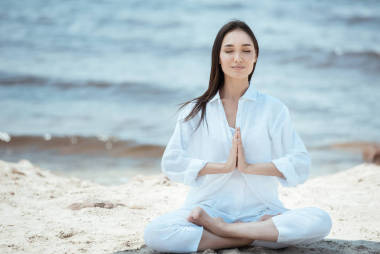 迷人的年輕亞洲婦女在安賈莉手印 (稱呼封印) 在海灘上的姿勢