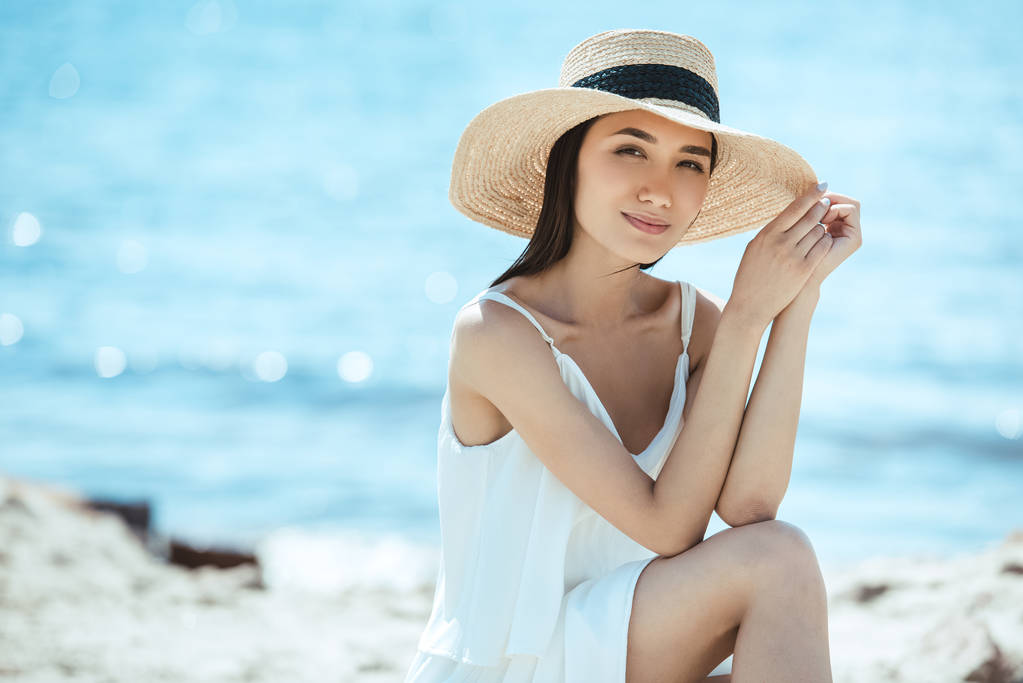 有吸引力的亚洲妇女在海滩草帽的选择焦点 有吸引力的亚洲妇女在海滩草帽的选择焦点