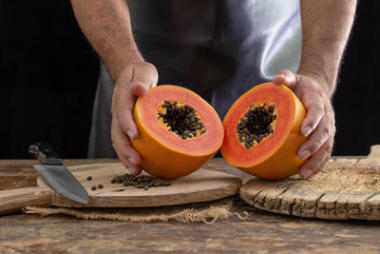 男子切割成熟的木瓜在木質(zhì)背景