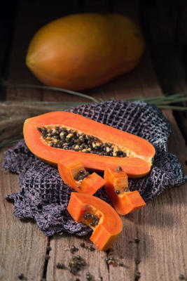 木瓜的木質(zhì)背景。一切片木瓜。成熟木瓜