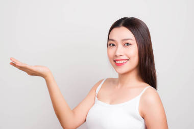 美麗的女人與完美的肖像。美麗的金發(fā)女郎 Spa 女孩顯示空白復(fù)制空間在打開(kāi)手掌的文本。提出一個(gè)產(chǎn)品。廣告手勢(shì)。在白色上隔離
