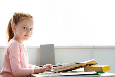 美丽的女学生在家学习时微笑着拍照