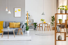 真实照片的露天空间内部与黄色垫子和毯子上的灰色沙发在生活区和木桌椅在用餐区