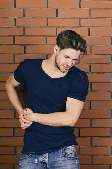 情緒, 疾病和醫(yī)療保健的概念。臉上不舒服的男子手放在左邊。深藍(lán)色 t恤的家伙肝臟疼痛