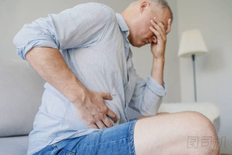 可怕的胃痛。沮喪英俊的年輕男子抱著他的腹部, 并保持眼睛緊閉。胃痛的不安男性