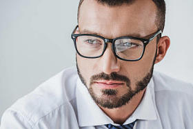 肖像英俊的商人在眼镜看着远离孤立的白色