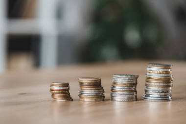 金融辦公室木桌上的硬幣堆圖片
