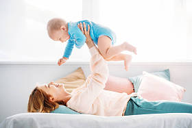 母亲在家里躺在床上的时候, 一边看着妈妈养育小孩