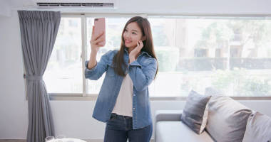 婦女在家愉快地電話自拍