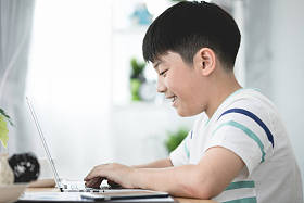 亚洲可爱男孩使用笔记本电脑