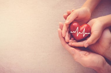 成人和儿童手抱着红色心脏与心电图, 健康关心爱和家庭概念