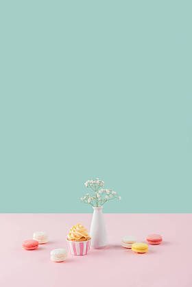 蛋糕和甜马卡龙在柔和的背景与花在花瓶 