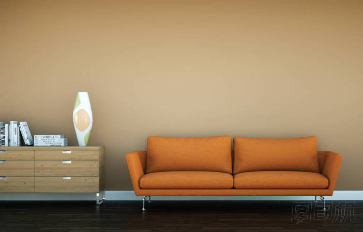 明亮的房間與橙色沙發(fā)在棕色墻壁前面