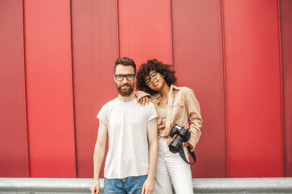 美丽的时尚年轻的多种族情侣在眼镜持有相机 美丽的时尚年轻的多种族情侣在眼镜持有相机