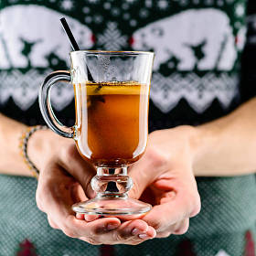 男子手持热黄油 Becherovka 鸡尾酒与蜂蜜, cinnamo