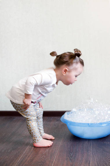 一个1.5 岁的女孩从事家务, 研究一个盆与泡沫, 化学化学。家庭例行, 儿童的危险在房子