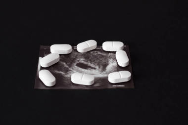 怀孕, 一枪的冲锋枪和丸在黑色的背景。堕胎, 特写