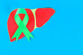 世界肝炎日。6月28日。翡翠绿丝带和蓝色桌子上的肝脏。复制空间
