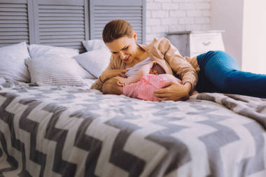 平靜的女人微笑, 而母乳喂養(yǎng)她可愛的嬰兒