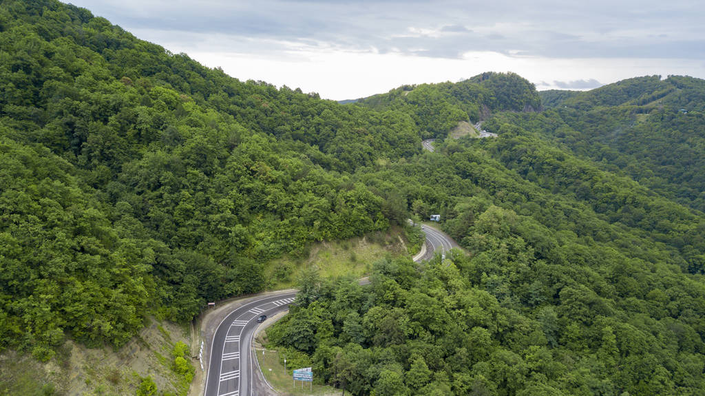 在俄罗斯索契的森林里, 沿着蜿蜒的山路行驶的汽车的空中股票照片。人行, 路之旅, 穿越美丽的乡村风光 在俄罗斯索契的森林里, 沿着蜿蜒的山路行驶的汽车的空中股票照片。人行, 路之旅, 穿越美丽的乡村风光