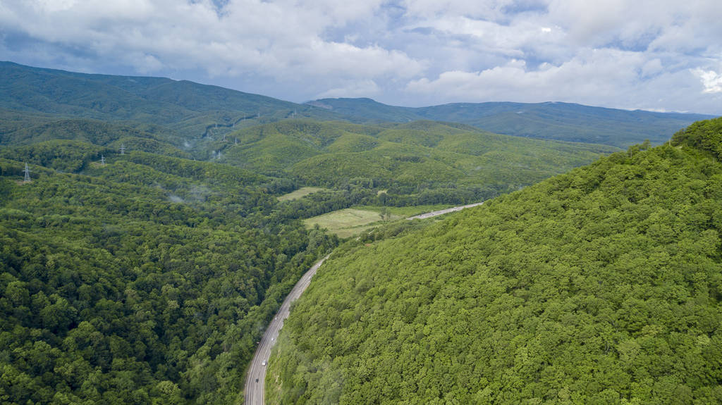 在俄罗斯索契的森林里, 沿着蜿蜒的山路行驶的汽车的空中股票照片。人行, 路之旅, 穿越美丽的乡村风光 在俄罗斯索契的森林里, 沿着蜿蜒的山路行驶的汽车的空中股票照片。人行, 路之旅, 穿越美丽的乡村风光