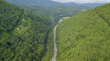在俄羅斯索契的森林里, 沿著蜿蜒的山路行駛的汽車的空中股票照片。人行, 路之旅, 穿越美麗的鄉(xiāng)村風(fēng)光