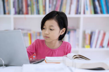 在圖書館學(xué)習(xí)時(shí)使用筆記本電腦的可愛女生形象