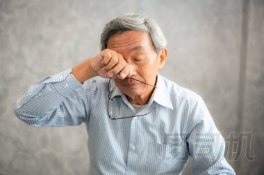 資深男子手持眼鏡, 揉他疲憊的眼睛, 而閱讀電子書在平板電腦