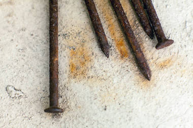 混凝土上生銹的釘子.圖片