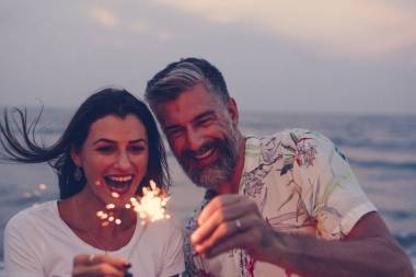 夫婦慶祝與煙花在海灘圖片