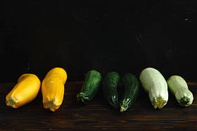 秋季收获南瓜和西葫芦品种的木质背景。带有复制空间的侧面视图