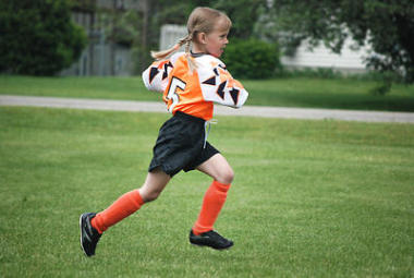 女孩在足球領(lǐng)域上運(yùn)行圖片